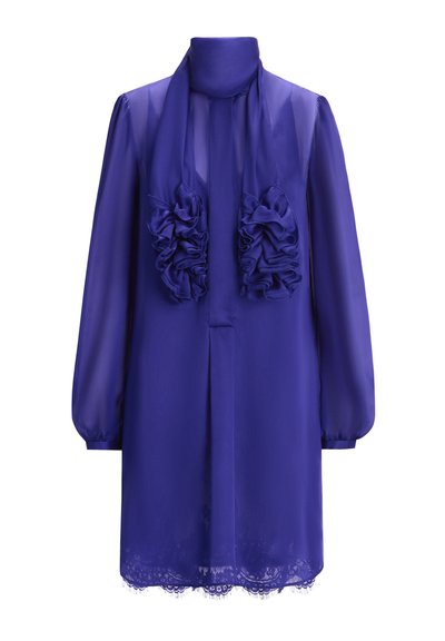 Paarse chiffon jurk met hoge hals, lange mouwen en ruches aan de voorkant. Heeft een zoom met kant aan de onderkant.