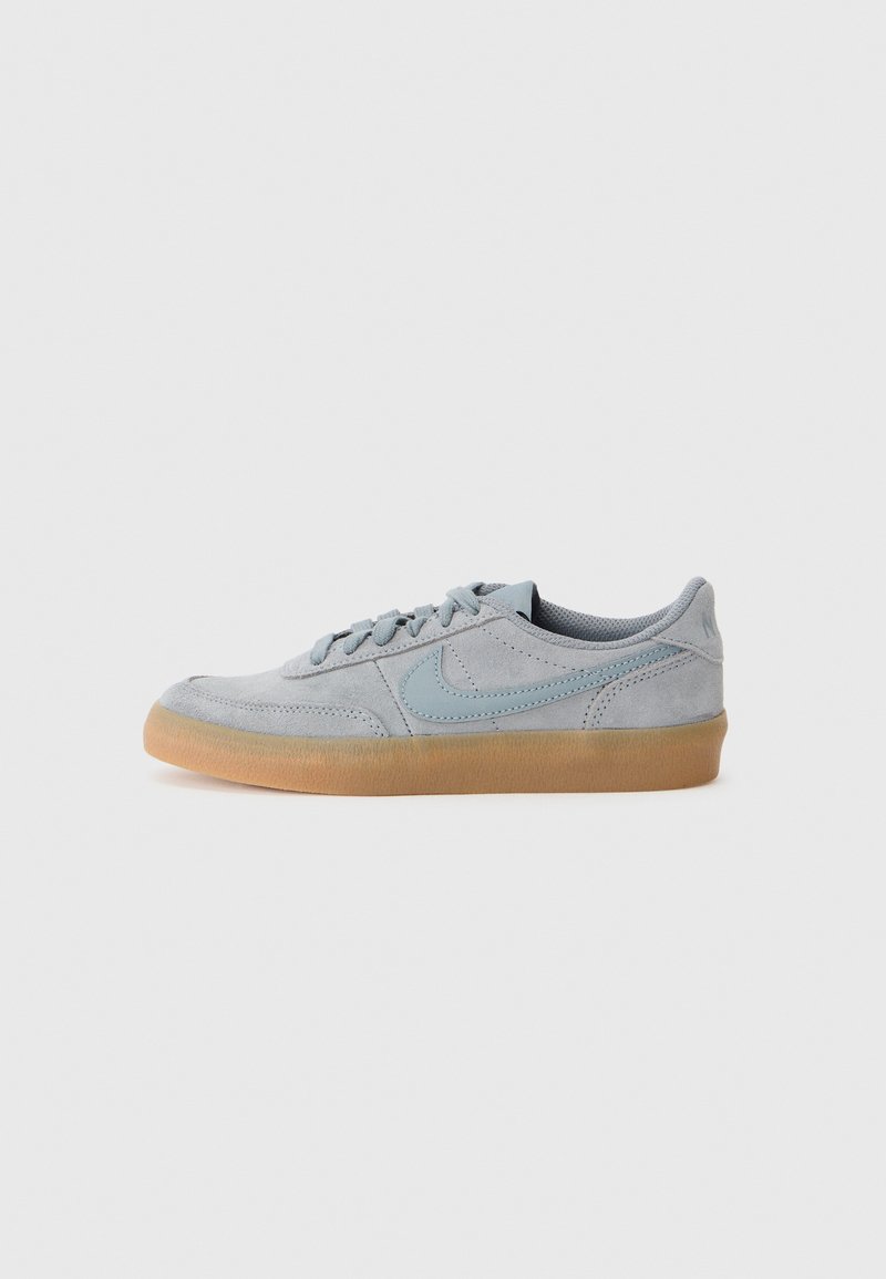Baskets en suède gris clair avec une semelle en caoutchouc gomme et des coutures texturées, ornées d'un logo Nike bleu doux sur le côté.