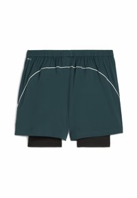 Mannen donker groene hardloopshorts met zwarte binnenste compressielaag en witte pipingdetails langs de randen van het voorpaneel.