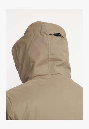 Bruine kapjacks met een gladde textuur en verstelbare toggles aan de achterkant van de capuchon, met zichtbare stiknaden en een schoon, minimalistisch ontwerp.