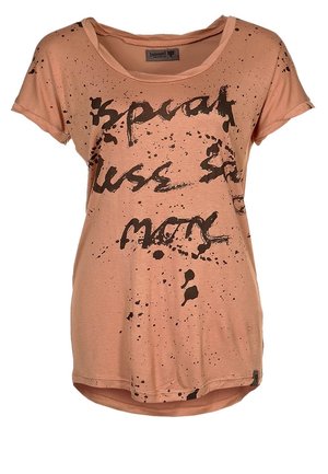 Brzoskwiniowa koszulka z okrągłym dekoltem, krótkimi rękawami i czarnym nadrukiem w formie plam. Miękki materiał z lekko zaokrąglonym dołem.