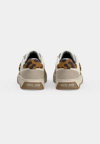 Une paire de baskets beige et marron avec un détail imprimé léopard sur le talon et le logo "roberto cavalli" sur la semelle arrière.