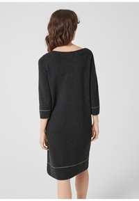 Tmavě šedé pletené šaty s třičtvrtečními rukávy, kulatým výstřihem a bílým lemem na rukávech a spodním lemu, s uvolněným střihem a lehce tapered tvarem.