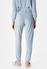 Pantalones de pijama de terciopelo azul claro con rayas texturizadas, cinturilla elástica y puños ajustados. Diseño suave y casual para comodidad y facilidad.