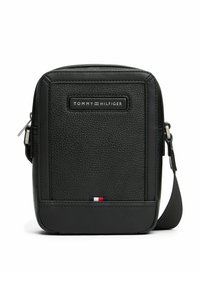 Bolso de hombro de cuero negro texturizado con cierre de cremallera, que cuenta con una placa de logo en la parte frontal y un acento tricolor en la parte inferior.