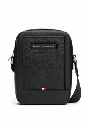Borsa a spalla in pelle nera testurizzata con chiusura a zip, con una placca logo frontale e un accento tri-colore sul fondo.