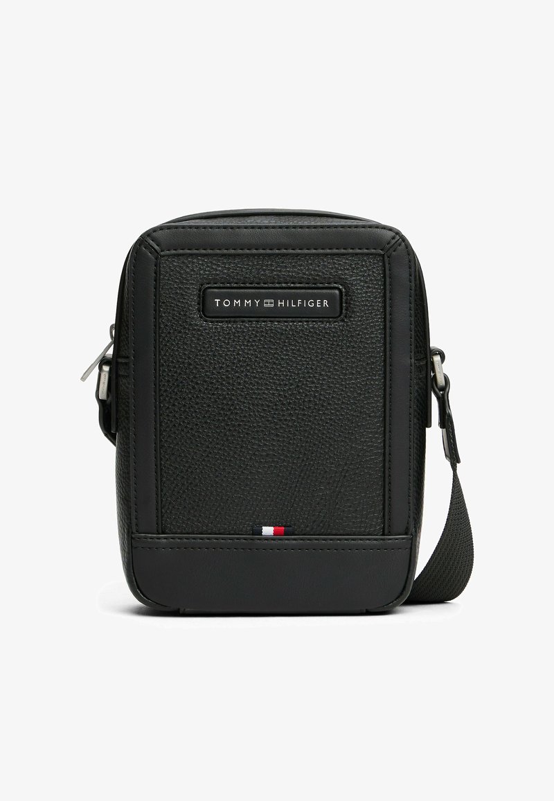 Bolso de hombro de cuero negro texturizado con cierre de cremallera, que cuenta con una placa de logo en la parte frontal y un acento tricolor en la parte inferior.