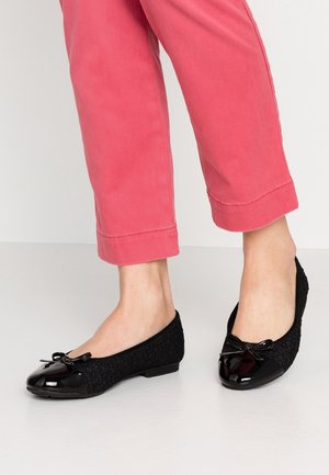 Zwarte balletschoenen met een glanzende laktoepassing, een textiele bovenkant met bloemenpatronen en een strikaccent aan de voorkant.