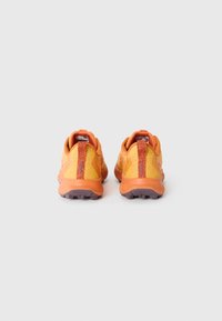 Baskets de sport orange vif avec tige en maille, col rembourré, languette texturée et semelle en caoutchouc violette avec des crampons de traction.