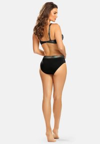 Czarny zestaw bikini z wzorzystym biustonoszem i wysokim stanem, ozdobiony błyszczącym akcentem. Gładka faktura, wspierające ramiączka i klasyczny design.