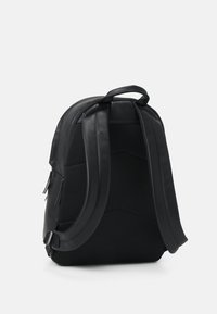 Sac à dos noir contenant un mélange de cuir et de matériaux en maille, au design contouré, avec des bretelles rembourrées et des détails zippés.