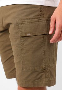 Shorts cargo kaki en tissu texturé, dotés d'une poche latérale et d'une étiquette OXBOW, avec des coutures renforcées le long de l'ourlet.