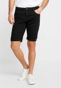 Black denim shorts with a classic cut, featuring pockets and a cuffed hem, paired with white sneakers.