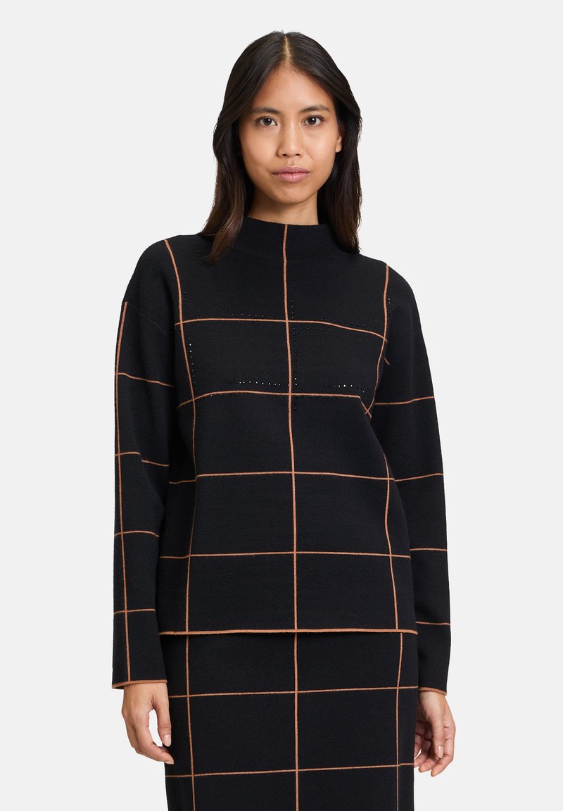 Schwarzer Pullover mit hohem Kragen, der ein Gittermuster in Orange aufweist. Das Material wirkt weich, hat lange Ärmel und eine lässige Passform.