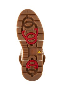 Podeszwa brązowego zamszowego buta z ozdobnym bieżnikiem, czerwonymi i żółtymi akcentami oraz okrągłym elementem wzorniczym zapewniającym lepszą przyczepność i stabilność.