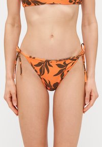 Pomarańczowe majtki bikini z brązowym kwiatowym wzorem, związane po bokach. Wykonane z gładkiej tkaniny, oferują dopasowany krój.