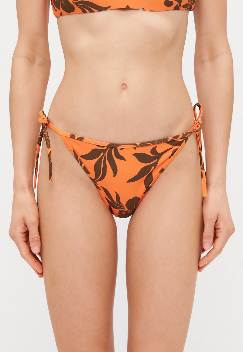 Pomarańczowe majtki bikini z brązowym kwiatowym wzorem, związane po bokach. Wykonane z gładkiej tkaniny, oferują dopasowany krój.