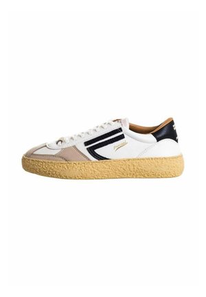Sneaker bianco e beige con suola tan testurizzata, dettagli neri e strisce decorative, dotato di una chiusura con lacci e superficie in morbida pelle.