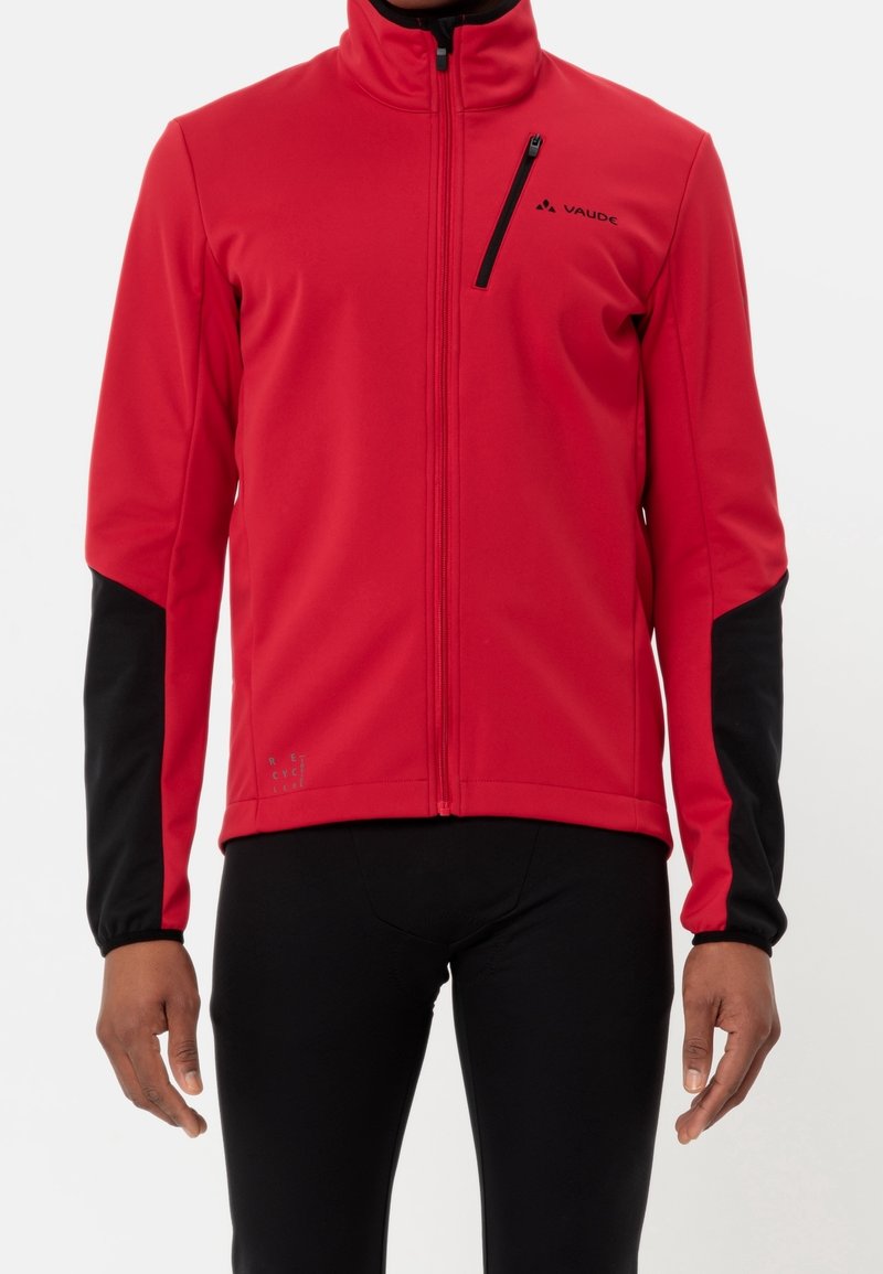 Veste softshell rouge avec accents noirs, col haut, fermeture éclair complète à l'avant et détails du logo. Comprend des manches longues et un tissu extensible.