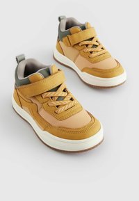 Tan en beige hoge sneakers van textiel, met klittenbandsluiting en veters. Rubber zool met een contrasterend bruin loopvlak.