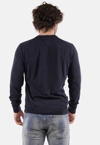 Maglione lavorato a maglia blu navy con scollo rotondo, polsini e orlo a costine. Presenta una texture liscia e un design aderente. Vista posteriore.