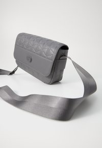 Šedá kožená crossbody taška s texturovaným geometrickým vzorem, magnetickým uzávěrem a širokým nastavitelným popruhem.