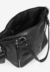 Bolso de mano de piel negra con un acabado texturizado, múltiples bolsillos con cremallera y acentos de tachuelas decorativas. El interior está forrado en tela negra.