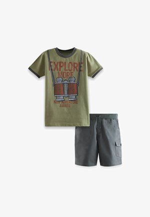 T-shirt en coton vert avec un motif de "jumelles" et un short gris avec une taille élastique et des poches latérales.