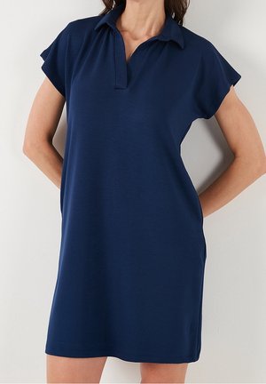 Granatowa sukienka polo z krótkimi rękawami, kołnierzykiem i luźnym krojem. Wykonana z gładkiej, lekkiej tkaniny bez widocznych wzorów.