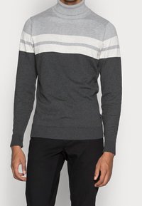 Maglione grigio a collo alto con righe orizzontali in grigio chiaro e bianco. Realizzato in tessuto a maglia testurizzato, con polsini e orlo a costine.