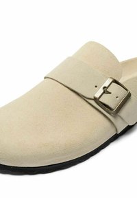 Zoccolo in suede beige con una ampia cintura e fibbia in metallo. Dotato di punta arrotondata e suola in gomma testurizzata per presa e comfort.