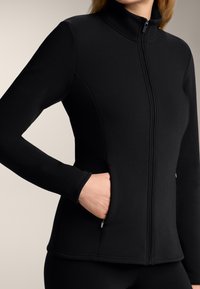 Czarna kurtka typu mock-neck wykonana z gładkiego materiału, z zamkiem z przodu, kieszeniami bocznymi i dopasowanymi długimi rękawami z detalami szwów.