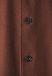 Bruine wol coat met twee zwarte knopen, met een gladde textuur en een strakke, op maat gemaakte stijl met zijkoekn.