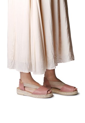 Roosad nahast espadrillid avatud varbaosaga, elastsete külgsidemetega ja punutud jookealusega, kombineeritud voolava kreemika värvi seelikuga.