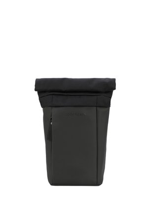 Sac à dos noir à rabat, avec une texture lisse, comportant une poche zippée sur le côté et un logo en relief sur le devant.