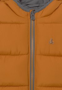 Pomarańczowa kurtka puchowa z szarym zamkiem błyskawicznym i szarym kapturem. Oferuje pikowane sekcje oraz małe logo misia wyszyte na klatce piersiowej.