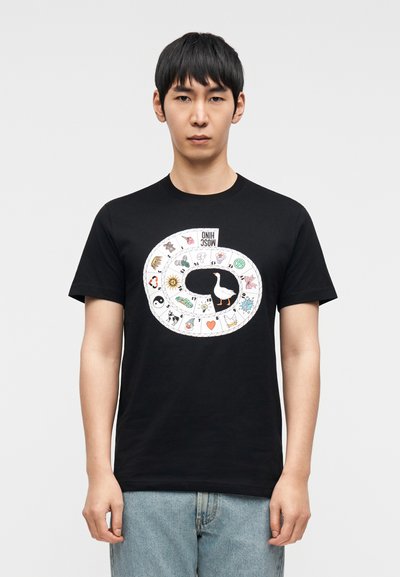 Μαύρο βαμβακερό κοντομάνικο μπλουζάκι με πολύχρωμο κυκλικό γραφικό που περιλαμβάνει διάφορα εικονίδια και μια κεντρική εικόνα πάπιας. Άνετη εφαρμογή με κοντά μανίκια.