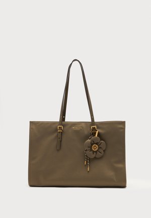 Oliven grøn Michael Kors tote taske med dobbelte skulderstropper, gulddetaljer og en blomsterformet vedhæng foran.