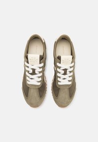 Olive green suede sneakers with white laces, a contrasting rubber sole, and a reinforced toe. GANT logo visible on the tongue.