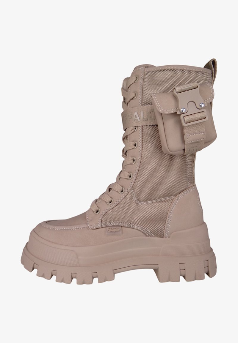 Stivaletto alto beige con tomaia in nylon testurizzato, suola in gomma spessa e una tasca attaccata sul lato per ulteriore spazio di stoccaggio.