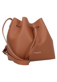 Borsa a secchiello in pelle marrone con una superficie morbida e testurizzata, tracolla regolabile e chiusura con cordoncino. Presenta logo del marchio impresso.