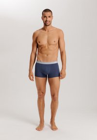 Marina boxershorts i stretchtyg, med ett mjukt grått midjeband som har "Hanro"-logotypen. Passformen är åtsittande och modern.