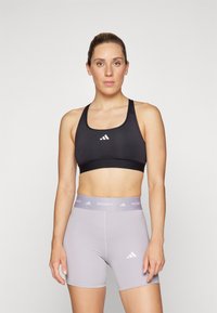 Svart treningstopp med sølvfarget logo, kombinert med lysegrå Techfit shorts som har elastisk midje og logodetalj. Glatt, atletisk passform.