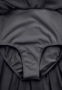 Robe noire en tissu doux et lisse. Corsage ajusté se transforme en jupe fluide, avec un design sans couture et une taille élastique.