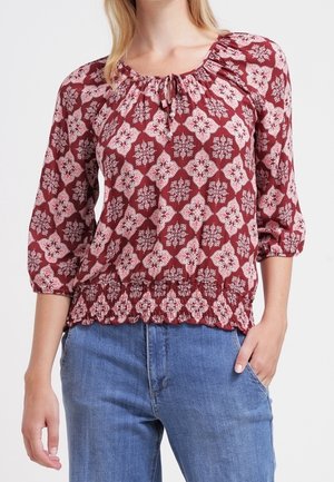 Maroon blouse with white floral pattern, scoop neckline with gathered detail, and 3/4 sleeves; features a peplum hem and textured fabric.