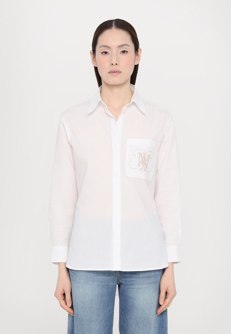 Witte blouse met lange mouwen van lichtgewicht materiaal, met een borstzak voorzien van een ingewikkeld beige monogramontwerp, een klassieke kraag en knoopsluiting.
