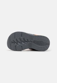 Skechers sko såle i mørkegrå med teksturert mønster, med en bred design og "SKECHERS" logo preget på siden.