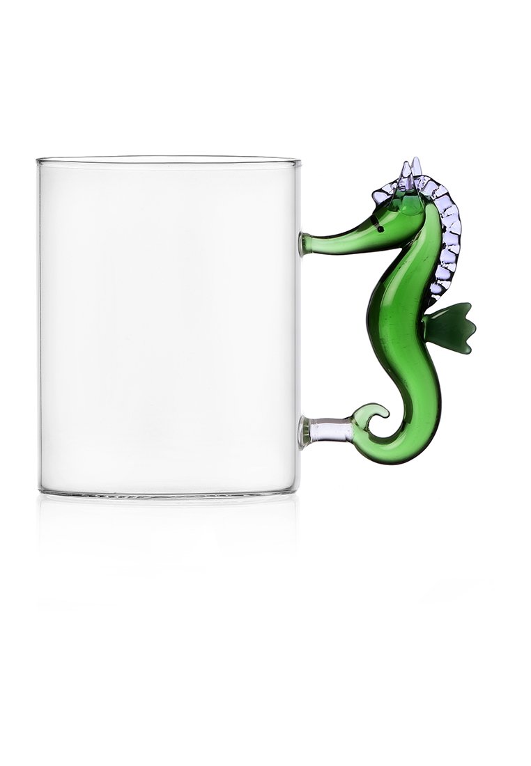 Przezroczysta szklanka z zielonym uchwytem w kształcie konika morskiego. Uchwyt ma szczegółowe łuski i ozdobną purpurową koronę na głowie.