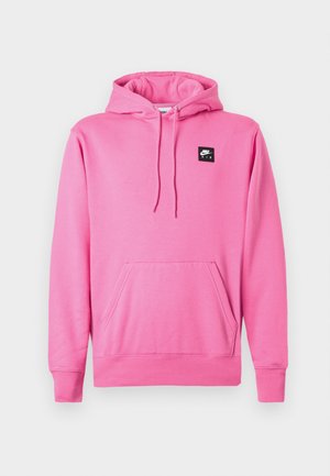Różowa bluza z kapturem z miękkiego materiału, z przednią kieszenią, kapturem ze sznurkiem i małym czarnym logo Nike Air na klatce piersiowej.