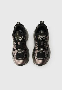 Sapatilhas atléticas pretas com acentos metálicos, painéis de malha e uma sola acolchoada. Os atacadores e a marca estão em destaque.